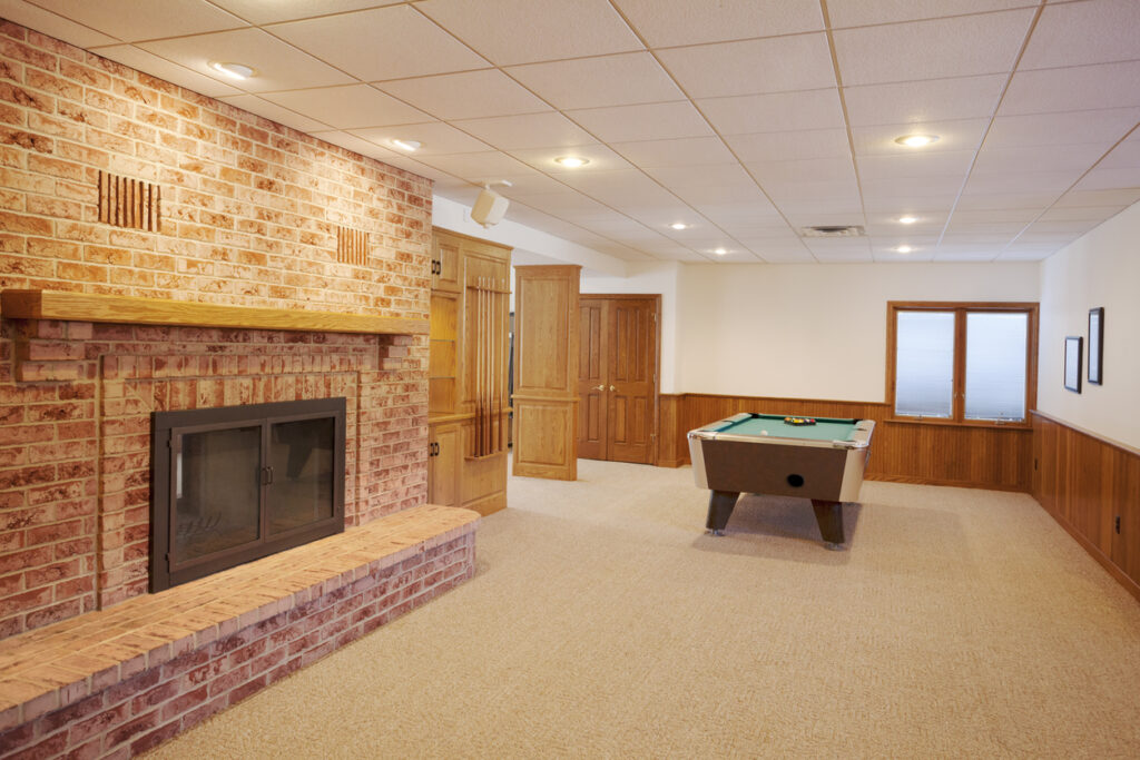 Spacious finished basement with pool table, fireplace, custom lighting.