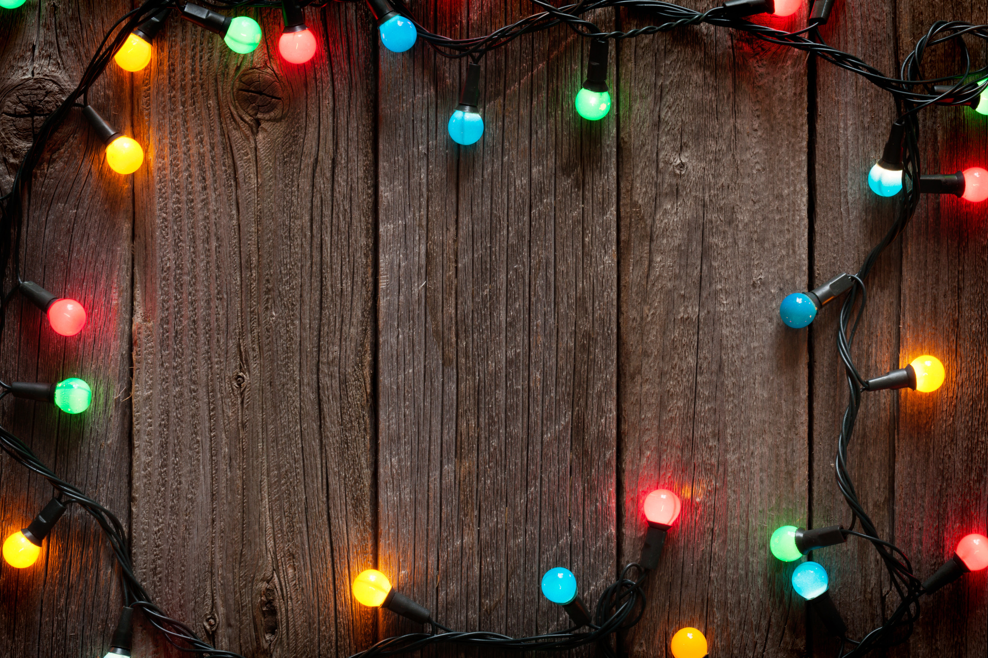 Christmas colorful lights frame on wooden table with copy space