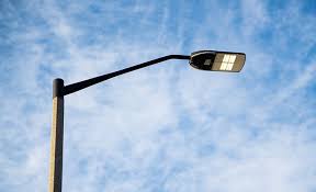 parking lot area light on top of pole with blue sky in background